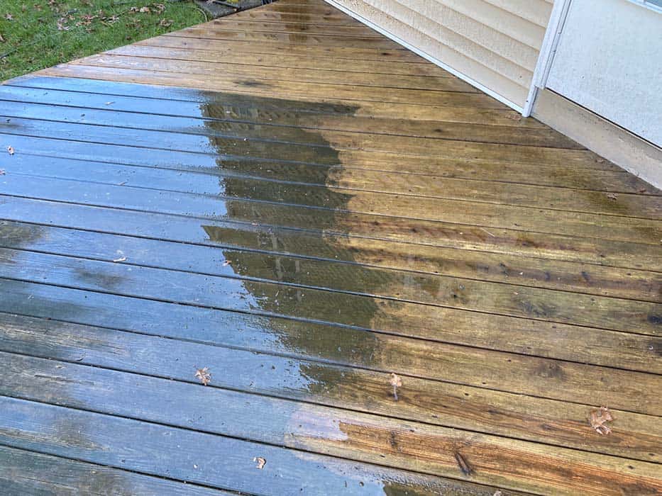Powerwashing deck in progress, showing before and after.
